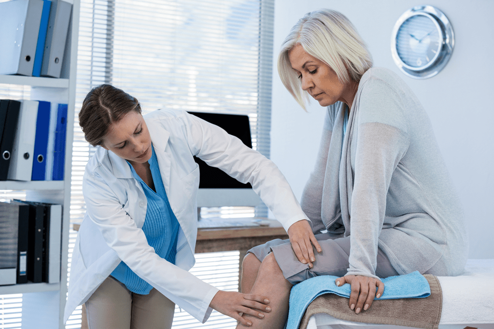Lékař vyšetřuje pacienta s artrózou kolenního kloubu